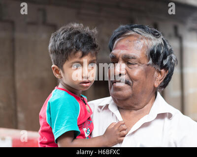 Indische Opa hält schaut auf seine Enkel und posiert für die Kamera Kapaleeshwarar Tempel, Mylapore, Chennai, Tamil Nadu Stockfoto