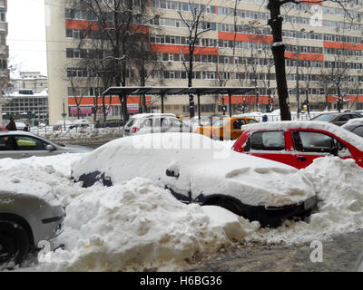 Parkende Autos von der Seite der Straße in Bukarest, Rumänien, mit Schnee bedeckt Stockfoto