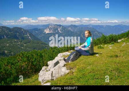 Junge Dame entspannen nach Wandern und genießen die Aussicht auf die Alpen. Hoher Dachstein, Österreich Stockfoto