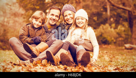 Lächelnde junge Familie sitzen in verlässt Stockfoto