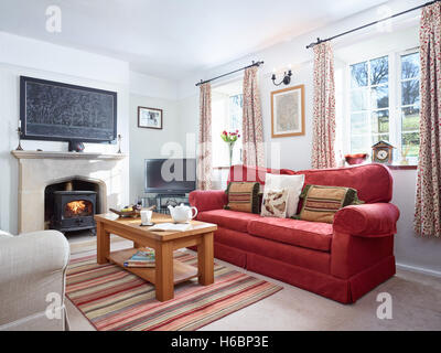 Ein gemütliches Wohnzimmer mit Kamin & einen Holzofen in einem komfortablen Landhaus. Stockfoto