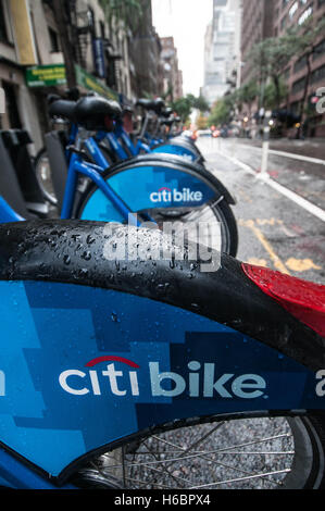 Citibikes angebunden an einer verregneten Straße in Manhattan, New York City, USA Stockfoto