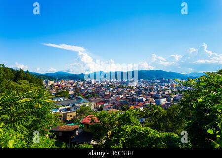 Luftbild aus Wald am Stadtrand von Hida-Takayama Gebäuden, Stadtbild und umliegenden Berge an einem Tag blauer Himmel in Gifu Stockfoto