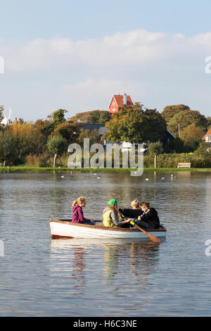 Jugendliche in einem Ruderboot auf Thorpeness Meare, Thorpeness Dorf, Küste von Suffolk, East Anglia, England UK Stockfoto