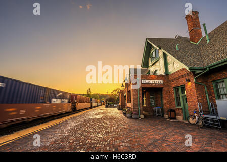 Amtrak Zug durch den historischen Bahnhof in Flagstaff bei Sonnenuntergang. Diese Station befindet sich auf der historischen Route 66. Stockfoto