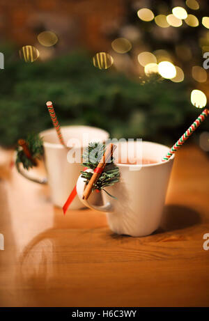 Zwei Tassen heiße Schokolade mit Zimt-sticks über Weihnachten Hintergrund. Winter Urlaub Konzept Stockfoto