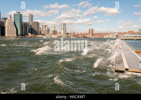 Die windigen, abgehackt Gewässer des East River Bruchs gegen ein Wellenbrecher im Brooklyn Bridge Park am Sonntag, 23. Oktober 2016 in New York. Windböen erreicht 55 mph mit der Stadt, die Erteilung einer Wind-Beratungs. Montag wird voraussichtlich mit weniger Wind wärmer sein. (© Richard B. Levine) Stockfoto