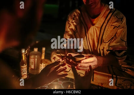 Ein Shipibo-Schamanen gibt ein Patient eine Tasse von Ayahuasca, traditionelle Amazonas Pflanzenmedizin für visionäre Heilung in Peru verwendet Stockfoto