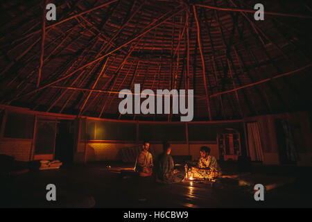 Ein Mann erhält eine Tasse von Ayahuasca, traditionelle Amazonas Pflanzenmedizin für visionäre Heilung in einer Shipibo Maloca in Peru verwendet Stockfoto