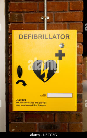 Gelbe Defibrillator Box auf eine äußere Mauer eines Einkaufszentrums, UK. Stockfoto