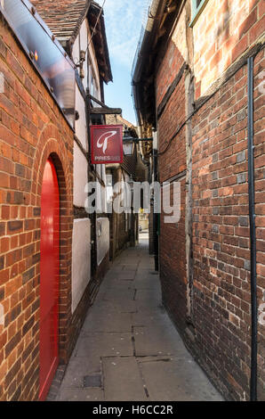 Schmale Gasse zwischen Carfax und Piries Hotel in Horsham, mit hängenden Zeichen von Piries Bar von Gebäuden aus dem 16. Jahrhundert. Stockfoto