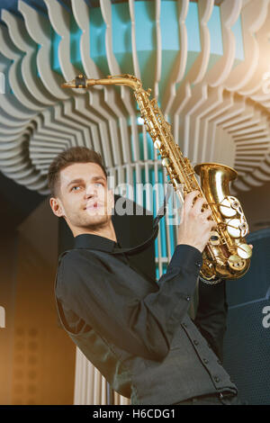 Junger Mann spielt ein Musikinstrument Saxophon Stockfoto