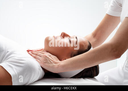 Porträt der jungen Frau an Reiki-Sitzung hautnah. Therapeut berührt Hals Wit Frauenhand. Stockfoto