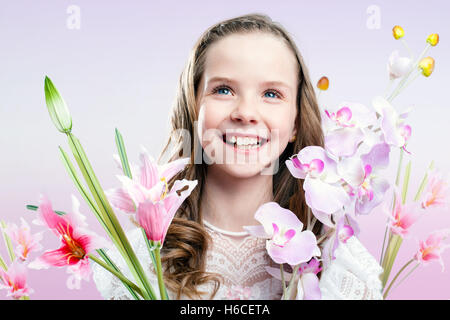 Großaufnahme Spaß Porträt Kommunion Mädchen mit bunten Blumen. Stockfoto