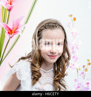 Hautnah Beauty Portrait von junge Mädchen in weißen Kommunion Kleid unter Blumen. Stockfoto