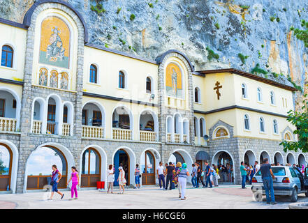 Die untere Kirche der Heiligen Dreifaltigkeit von Ostrog Kloster mit den zahlreichen Touristen und Pilger neben dem Eingang Stockfoto