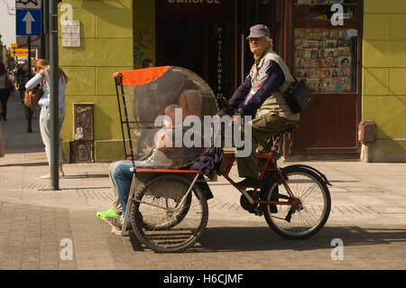 Europa, Polen, Lodz, Łódź, Ulica Piotrkowska, Velo-Rikscha in Betrieb Stockfoto