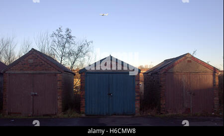 Baufälligen Schuppen noch gebräuchlich mit Flugzeug im Himmel heruntergekommen Stockfoto