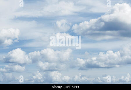 Viele weiße flauschige Wolken über einem tiefblauen Himmel Stockfoto