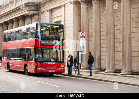 Londoner Doppeldeckerbus an einer Haltestelle mit Passagiere aussteigen. Stockfoto