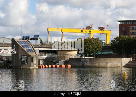 Der Lagan Weir auf dem Fluss Lagan mit Harland & Wolff Krane im Hintergrund. Stockfoto