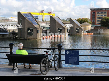 Der Lagan Weir auf dem Fluss Lagan mit Harland & Wolff Krane im Hintergrund. Stockfoto