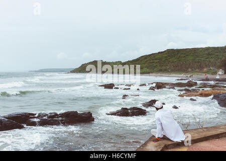 Lokale Mann anzeigen das stürmische Meer in Goa. Stockfoto