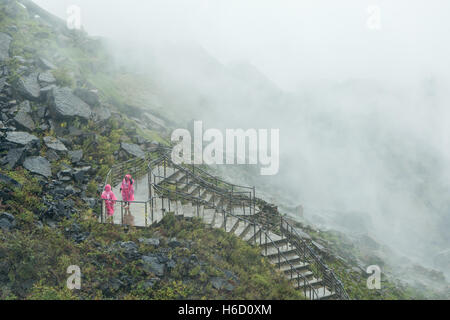 Menschen in Regenponchos trotzen dem Nebel und Spray von der amerikanischen Wasserfälle auf dem Weg zum Crows Nest in Niagara Falls, New York Stockfoto