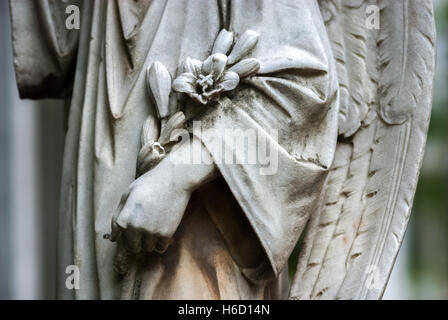 Details einer Engelshand mit Blumen, Teil einer weinenden Engelsfigur im Taman Prasati Museum (Museum des Gedenksteinparks) in Jakarta, Indonesien. Stockfoto