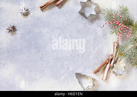 Weihnachten-Zweig und Zutaten für die Weihnachtsbäckerei - Gewürze, Mehl, Puderzucker und Ausstechformen zu gestalten. Saisonale, Essen b Stockfoto