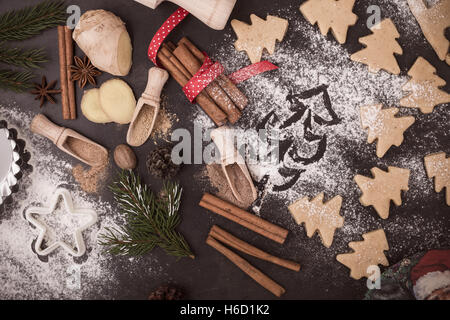 Rahmen der Zutaten und Maut für Lebkuchen Backen. Cookies und Gewürzen über rustikalen Tisch mit Weihnachtsbaum auf Mehl gemalt Stockfoto