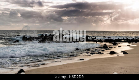 Ascension Island Felsen am Toten Mann Strand Georgetown bei Sonnenuntergang mit dunklen Wolken am Meer Stockfoto