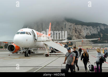 Passagiere von Easyjet Airbus A319 am Flughafen von Gibraltar, mit einer Wolke bedeckten Felsen hinter aussteigen Stockfoto