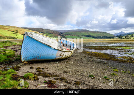 Isle Of Skye Schottland Landschaft. Alte verlassene hölzerne Boot Wrack mit blauen Farbe an den Strand zu Loch Harport peeling Stockfoto