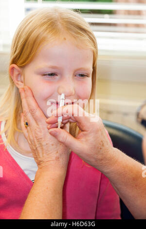 6 / 6 Jahre altes Kind erhält Dosis der Fluenz Grippe-Impfstoff Nasenspray Immunisierung von NHS Praxis Krankenschwester. VEREINIGTES KÖNIGREICH. Stockfoto