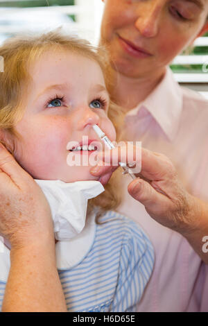 4 Jahre altes Kind mit ihrer Mutter / Mutter, erhält Dosis der Fluenz Grippe-Impfstoff Nasenspray Immunisierung von NHS Practice Nurse UK Stockfoto