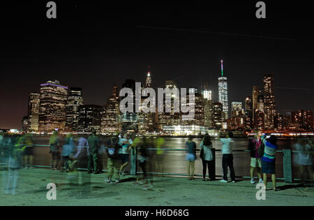 Menschen versammeln, um die Zeit Nachtansicht von lower Manhattan über den East River aus Brooklyn, NY, Vereinigte Staaten von Amerika zu bewundern. Stockfoto