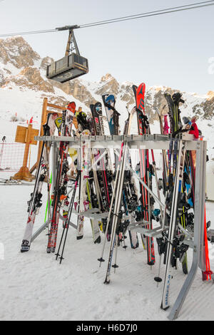 Outdoor-Ski Rack voller Ski im Skigebiet Courchevel 1850 mit La Saulire Seilbahn vorbei über Kopf Stockfoto