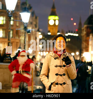 Porträt lächelnden Asiatin Besuch in London während der festlichen Jahreszeit, Weihnachten, big Ben im Hintergrund Stockfoto