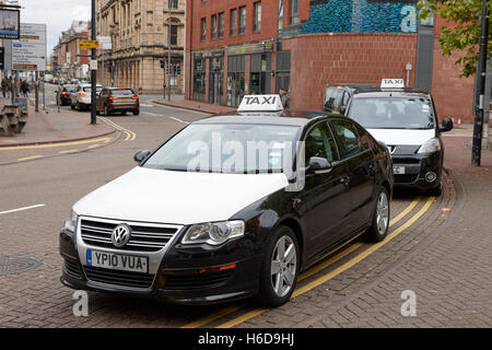 schwarze und weiße Taxis auf ein Taxi Rank in Cardiff Wales Vereinigtes Königreich Stockfoto