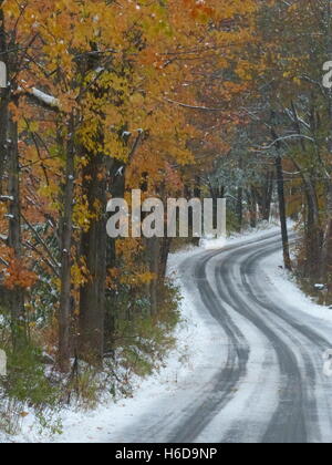 Kurvenreiche Straße im Winter mit Reifenspuren im Schnee Stockfoto