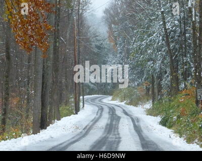 Kurvenreiche Straße im Winter mit Reifenspuren im Schnee Stockfoto