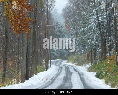 Kurvenreiche Straße im Winter mit Reifenspuren im Schnee Stockfoto