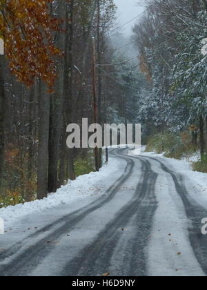 Kurvenreiche Straße im Winter mit Reifenspuren im Schnee Stockfoto