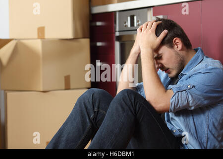 Sad vertrieben Mann besorgt versetzten Haus sitzen auf dem Boden in der Küche Stockfoto