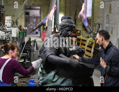 Berlin, Deutschland. 27. Oktober 2016. Heike Koller und Friedrich Lehmann setzen den letzten Schliff in der Bronze, Originalgröße Kopie der das Goethe-Denkmal des Bildhauers Schaper aus den Tiergarten in Berlin in der Knaak-Skulptur-Gießerei im Bezirk Oberschoeneweide in Berlin, Deutschland, 27. Oktober 2016. Die sechs Meter hohe Skulptur des deutschen Dichters Goethe bald außerhalb der Unternehmenszentrale des Konglomerats "Lotte" in Seoul, Südkorea stehen wird. Der Firmengründer und Goethe-Verehrer Shin Kyuk-Ho beauftragt das Stück bereits seine Firma nach Lotte in Goethes benannt haben Stockfoto