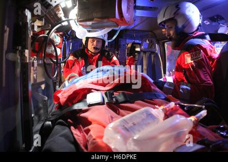 Suederstapel, Deutschland. 29. Oktober 2016. Notfall Sanitäter Frank Schmelzkopf (L) und Holger Harbs Arzt behandeln Statist, einen schwerverletzten Patienten in Rettungshubschrauber "Christoph 42" von der DRF-Luftrettung in Rendsburg stationiert, während eines Alarms Bohren mit der Feuerwehr und Rettungsdienste auf dem Sportplatz in Suederstapel, Deutschland, 29. Oktober 2016 darstellt. Die EC 145 Intensivpflege Hubschrauber von Airbus Helicopters Deutschland GmbH ist die aktuelle BK 117 ersetzt. Foto: Wolfgang Runge/Dpa/Alamy Live News Stockfoto