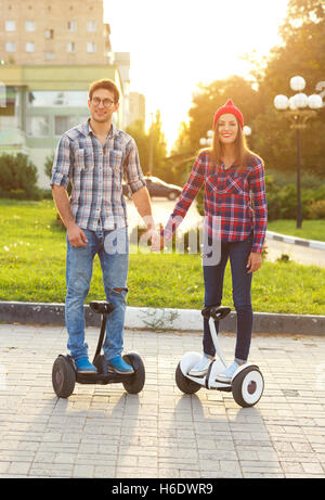 Junges Paar Reiten Hoverboard - elektrische Scooter, persönliche Eco Transport, Gyro Roller, intelligente Unruh. Neue moderne techn Stockfoto