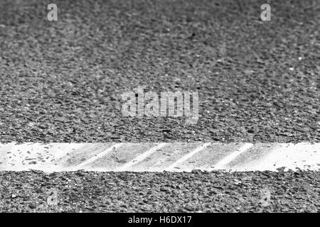 Trennlinie mit Reifen verfolgt über es, Autobahn Straßenmarkierung Fragment. Abstrakte Transport Hintergrund Stockfoto