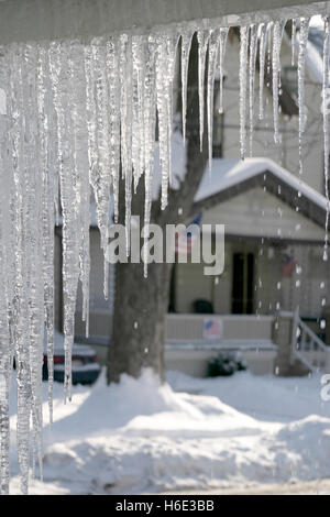 Schmelzende Eiszapfen an Dachrinnen angebracht Stockfoto